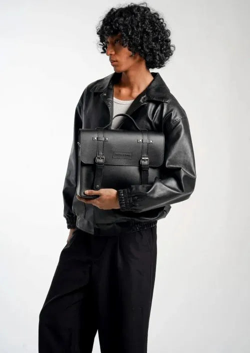 A man carrying a black laptop bag on his arm