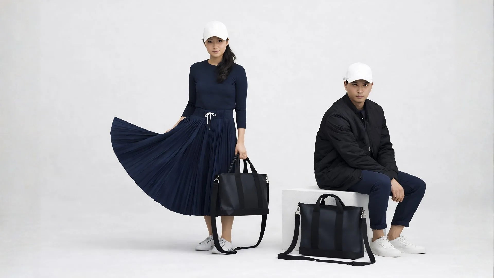 Two people holding black handbags against a white background