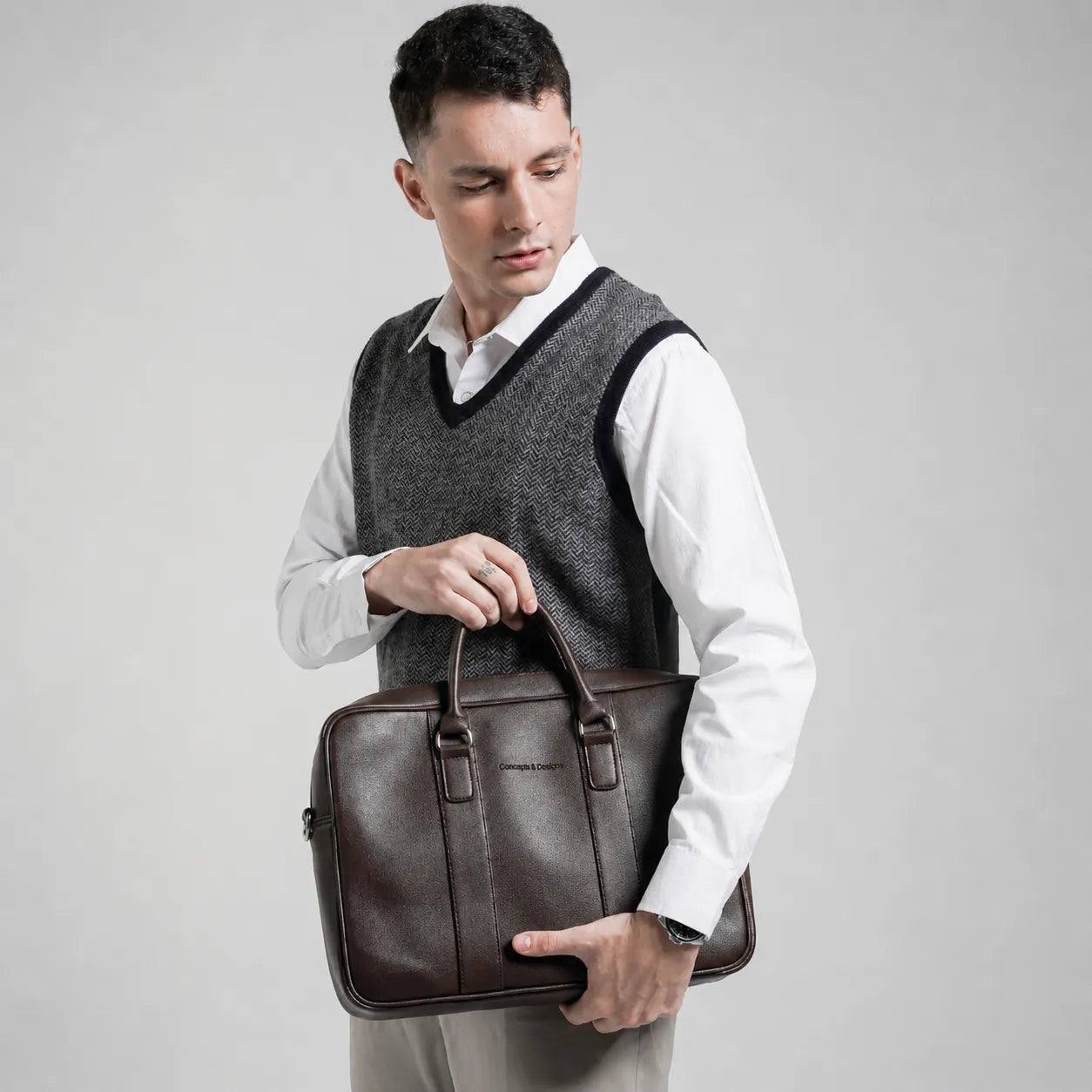 Man holding a brown leather briefcase against a plain background
#color_brown