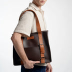 Man holding a brown leather bag against a white background
#color_espresso