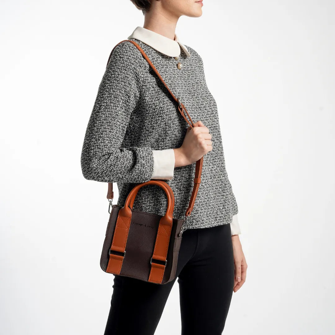 Person holding a brown leather bag against a white background
#color_espresso