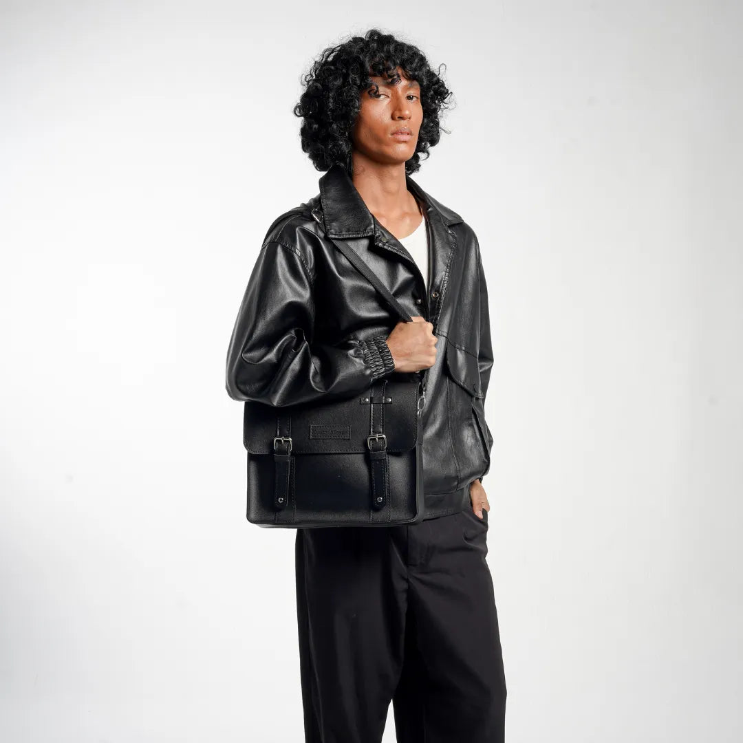 Man wearing a black leather satchel bag on a white background
#color_midnight