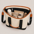 Open tote bag with black and white design, containing various items on a light gray background
#color_malibu