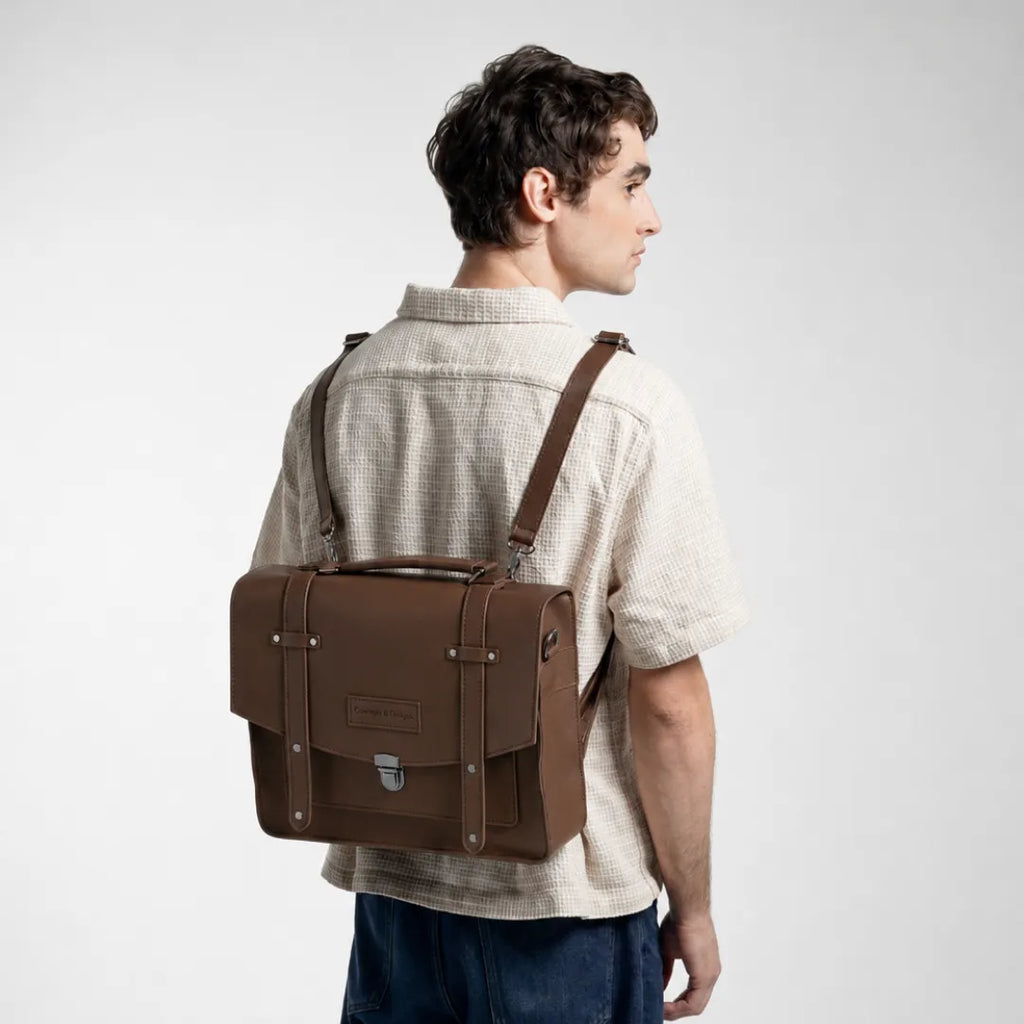 Man holding a brown leather briefcase against a white background
#color_dark brown