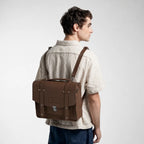 Man holding a brown leather briefcase against a white background
#color_dark brown