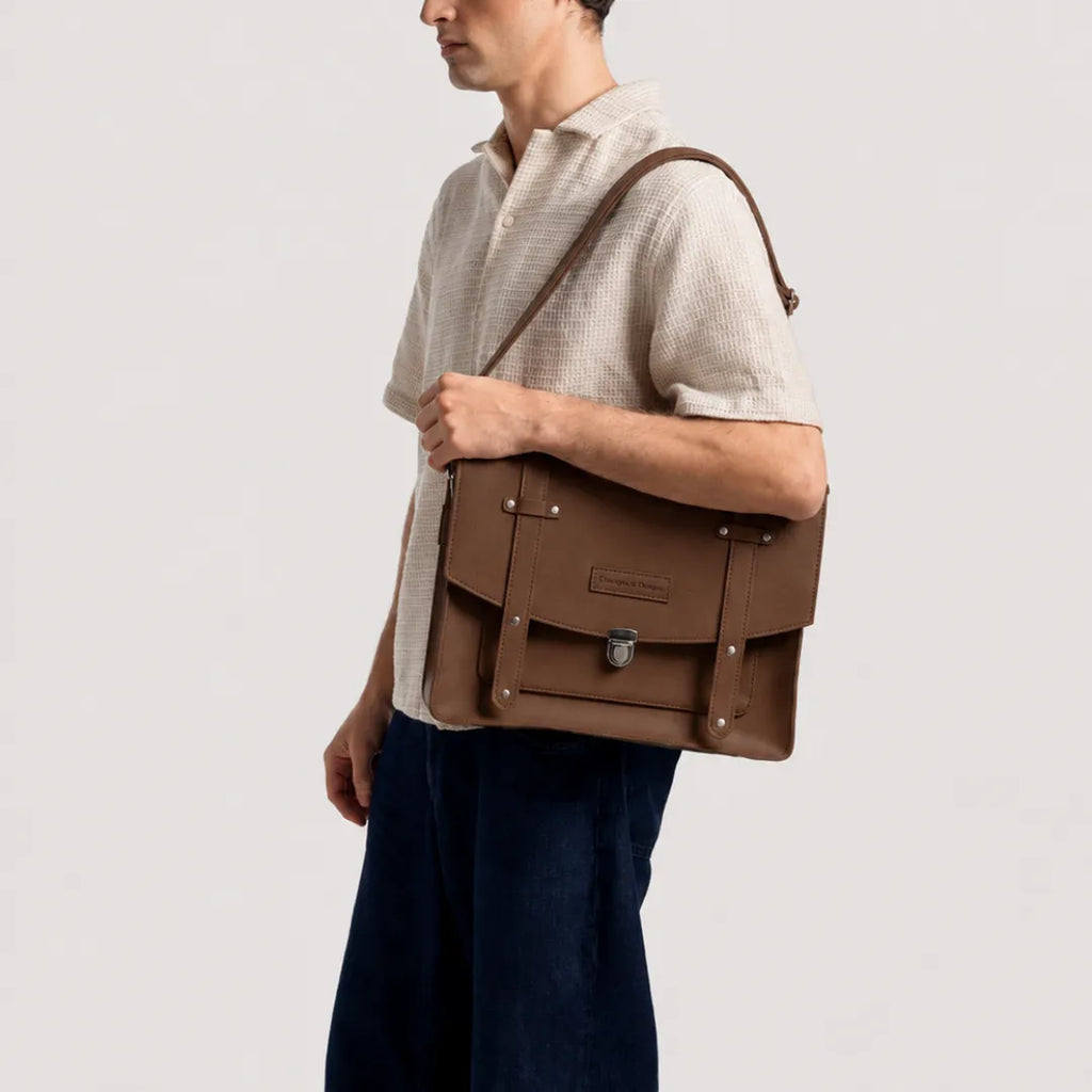 Man carrying a brown leather bag on a plain background
#color_dark brown