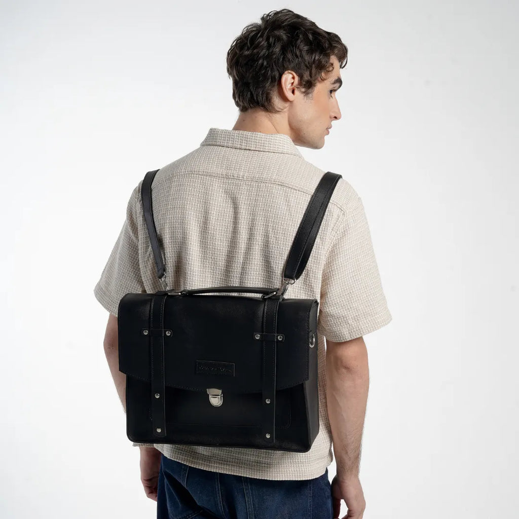 Man holding a gray leather bag against a white background
#color_midnight