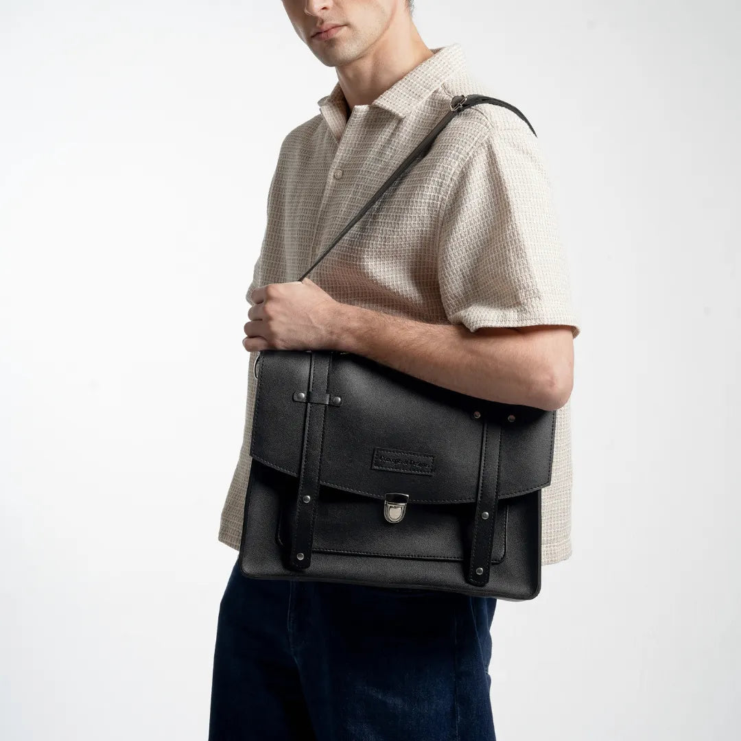 Man holding a black leather briefcase against a white background
#color_midnight
