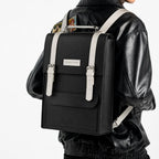 Person wearing a black backpack with white straps on a white background
#color_charcoal