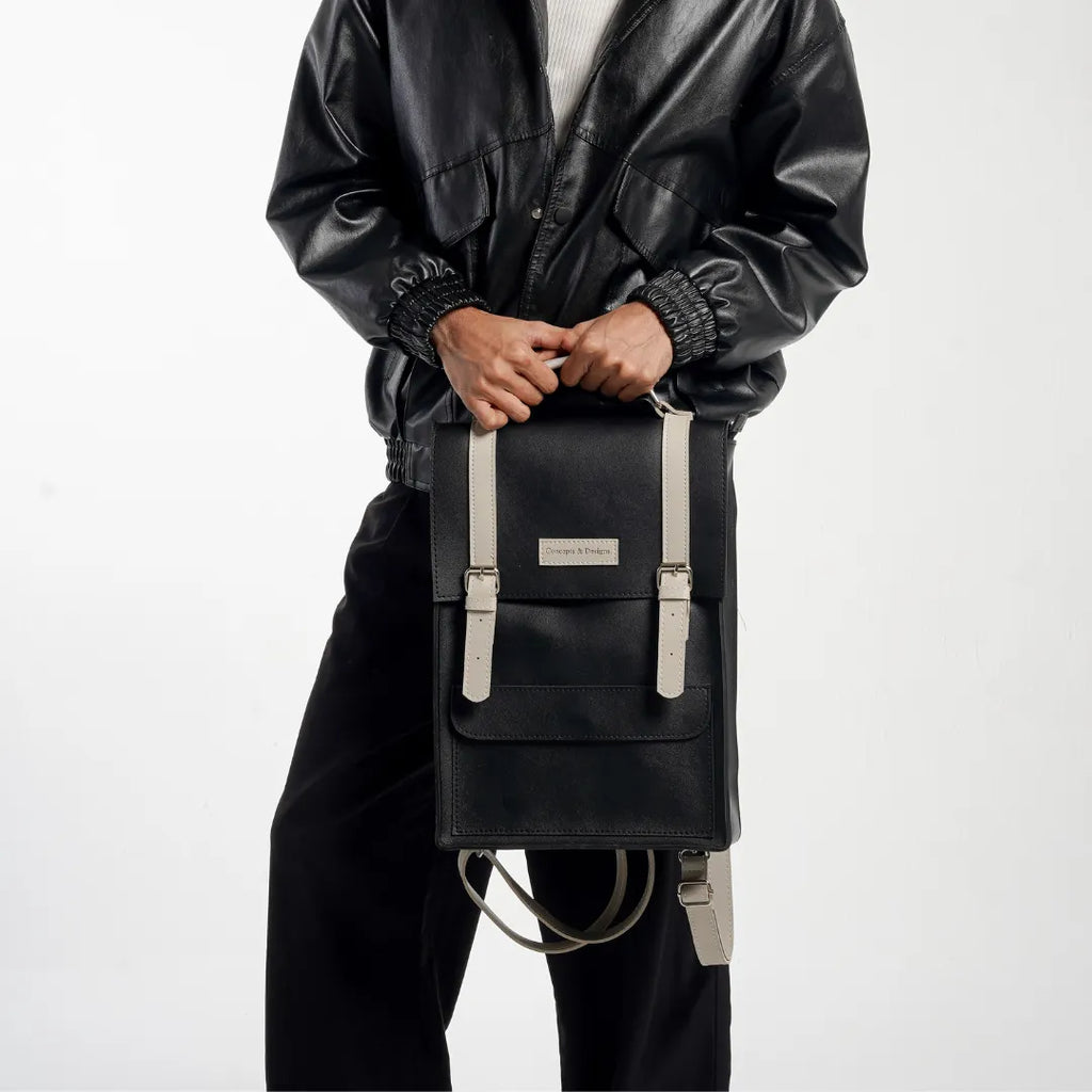 Man holding a black backpack with beige accents on a white background
#color_charcoal