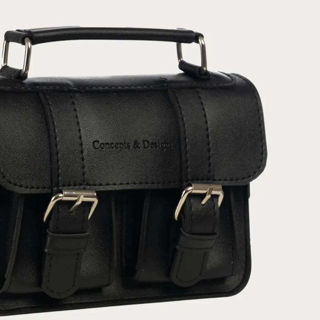 Black satchel bag with gold buckles on a light gray background
#color_midnight