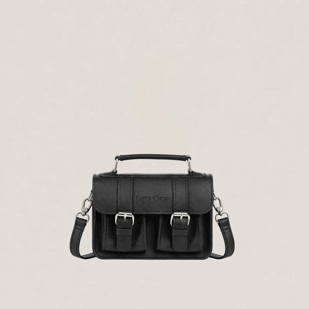 Black handbag with silver buckles on a light gray background
#color_midnight
