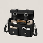 Black organizer bag with various items on a light gray background
#color_midnight