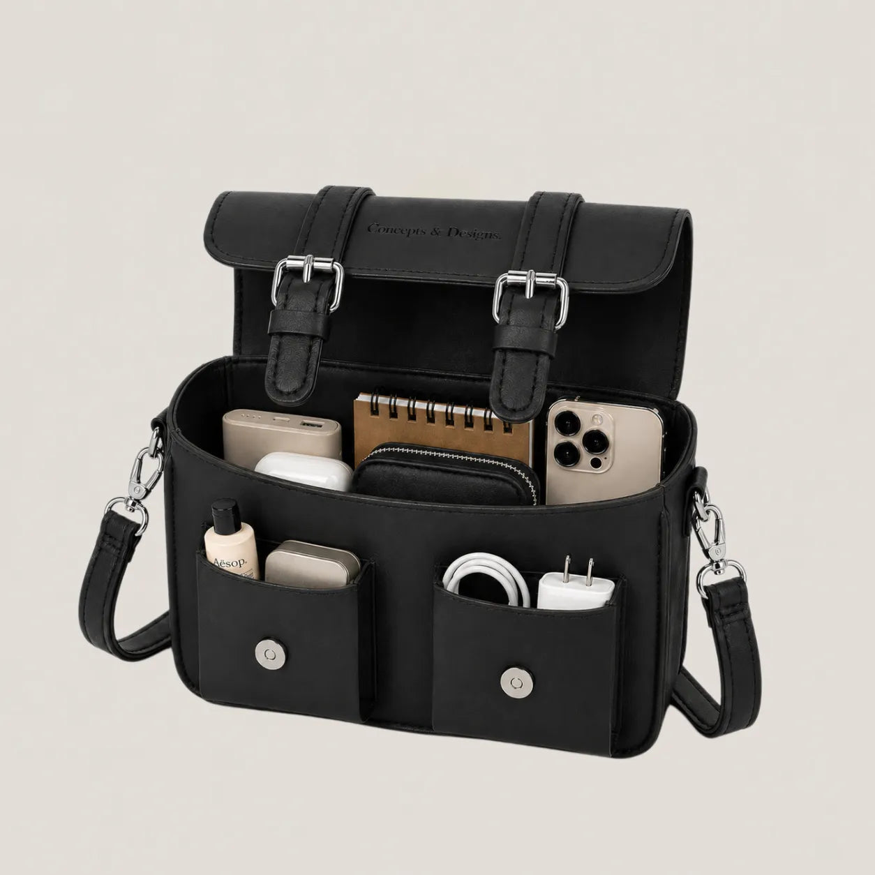 Black organizer bag with various items on a light gray background
#color_midnight