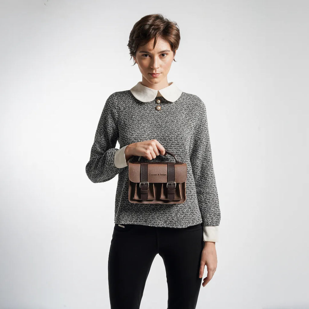 Person holding a brown leather tool belt against a white background
#color_umber