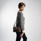 Person holding a brown leather tool bag against a white background
#color_umber