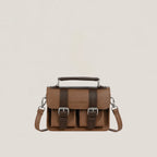 Brown leather satchel bag with silver buckles on a beige background
#color_umber