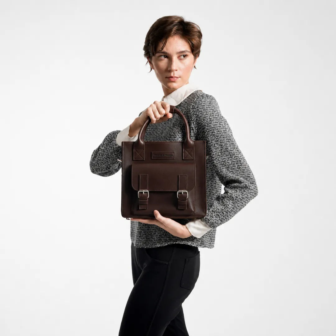 Woman holding a brown leather bag against a white background
#color_dark brown
