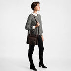 Woman holding a brown leather bag against a white background
#color_dark brown