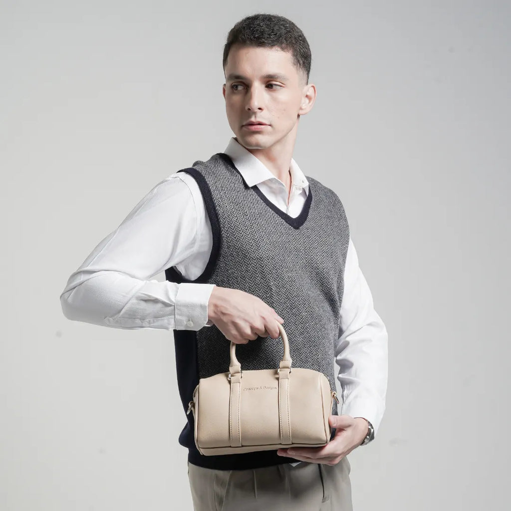 Woman holding a beige handbag against a plain background
#color_light beige