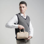 Woman holding a beige handbag against a plain background
#color_light beige
